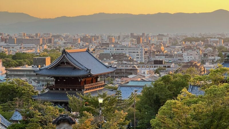 sunset views over Kyoto Japan with Pagodas next to modern buildings