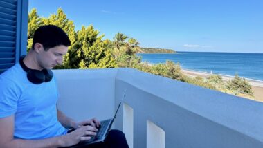 digital nomad on laptop overlooking Aegean Sea in Greece for digital nomads