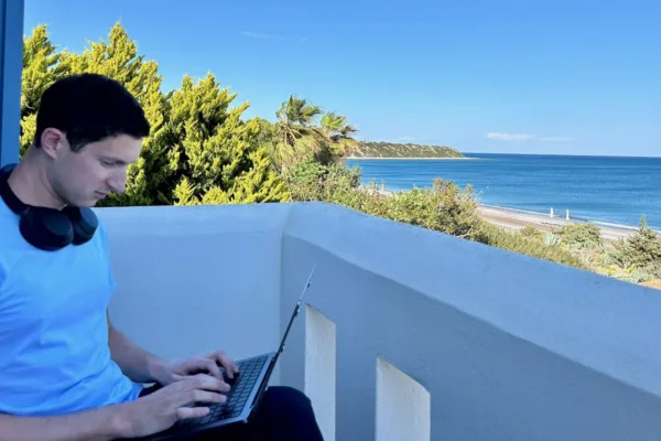 digital nomad on laptop overlooking Aegean Sea in Greece for digital nomads