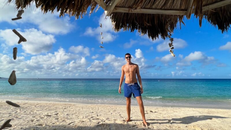 travel blogger on a crystal white sand and turquoise blue beach on one of the best beaches in curacao