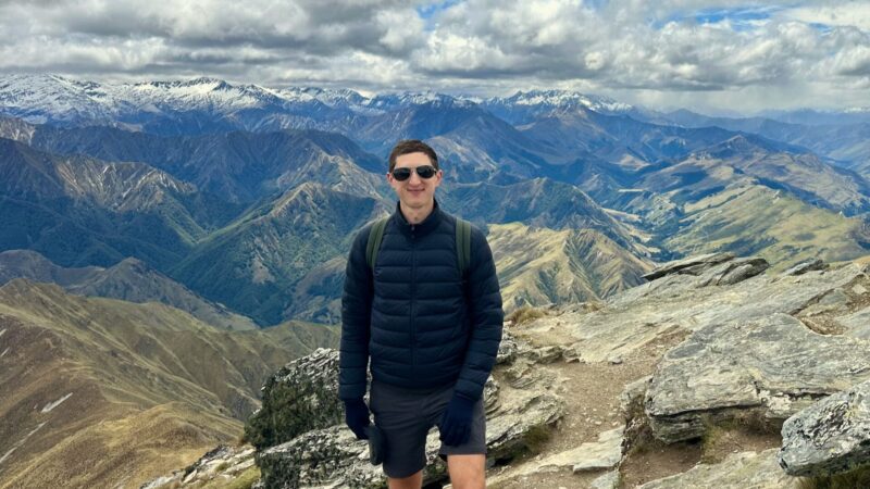 Hiker on mountain summit, scenic view of Ben Lomond Hike track near queenstown