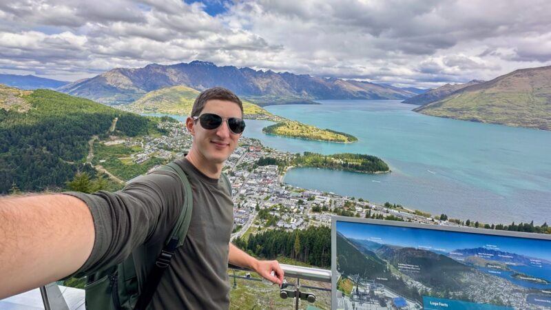 travel blogger overlooking sweeping views of Queentown from Bob's Peak, one of the best things to do in Queenstown