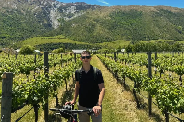 Biker in vineyard with mountains backdrop on the Gibbston Valley Wine Trail near Queenstown