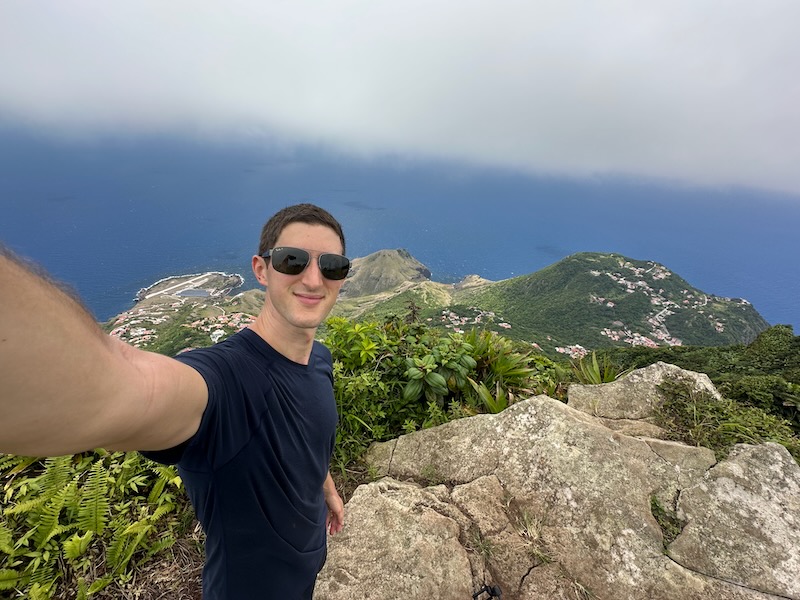 man standing at the highest point in Saba mount scenery