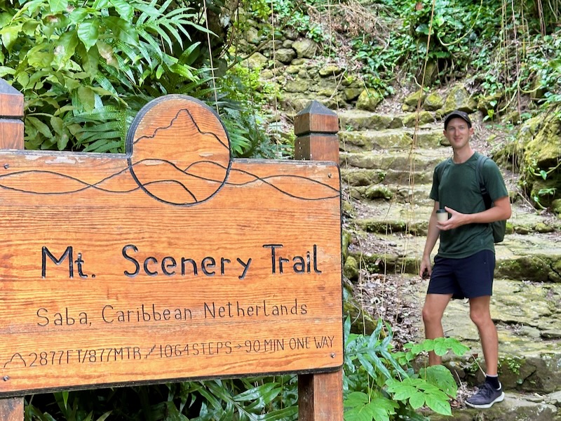 man standing at the mount scenery trailhead in saba
