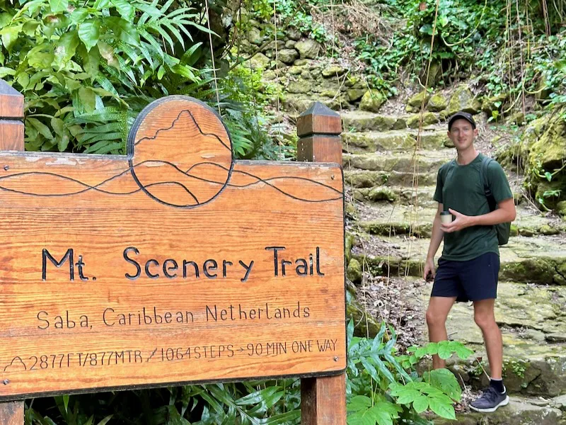 man standing at the mount scenery trailhead in saba