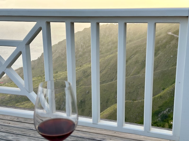 Spyglass Villa Saba luxury villa at sunset with wine overlooking the sea and rolling cliffs below