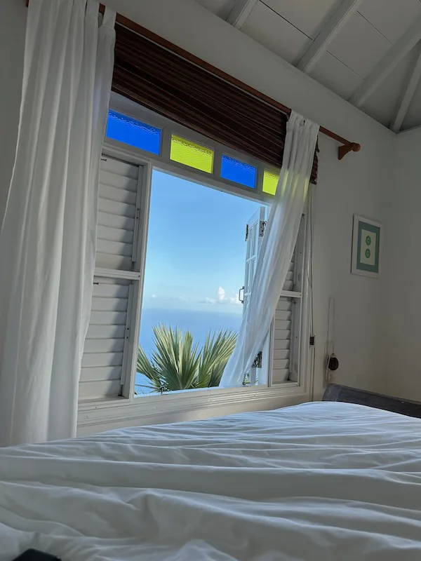 bedroom view from Saba luxury villa looking out to palm trees and Caribbean Sea
