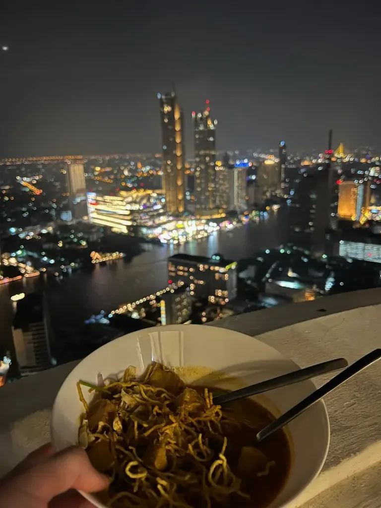 eating take out on balcony at State Tower in Bangkok, Thailand
